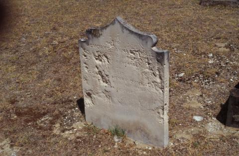 A weathered limestone headstone that shows erosion and discolouration from lichen.