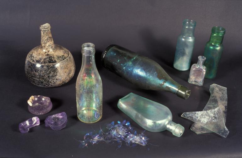A selection of different glass bottles and containers that are iridescent caused by glass deterioration.